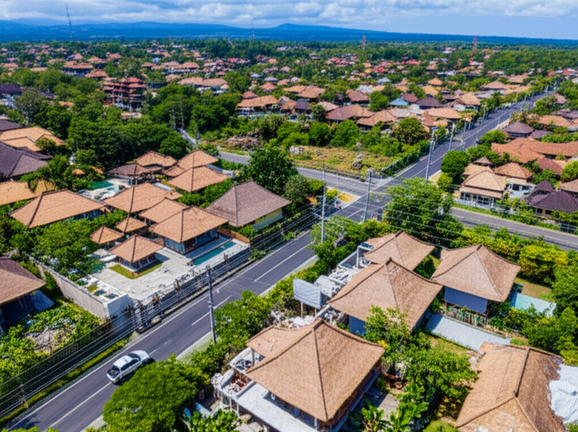 Aerial view of Bali showing diverse construction projects, including luxury villas, resorts, infrastructure, and traditional Balinese architecture, illustrating the island's dynamic growth.