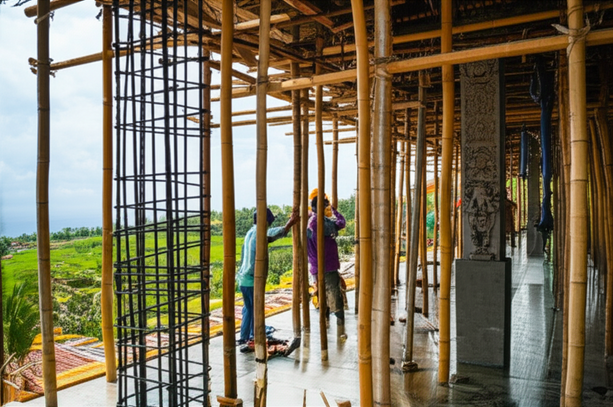 Construction site in Bali showing a building in progress with traditional Balinese elements and modern construction techniques.