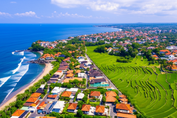 Aerial view of Bali's coastline, highlighting Seminyak's luxury villas, Canggu's blend of surf culture and modern villas, and Ubud's rice terraces.
