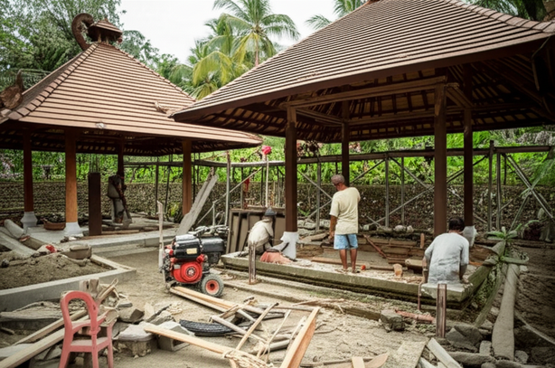 Construction of a villa in Bali, showcasing local workers and traditional Balinese architecture.