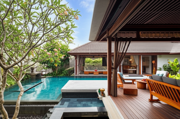 A luxurious Bali villa showcasing a seamless blend of interior design and outdoor living spaces with an infinity pool and lush tropical landscaping.