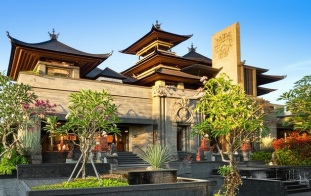 Architectural rendering of a commercial building in Bali, blending modern design with traditional Balinese elements, sustainable features, and lush tropical landscaping.