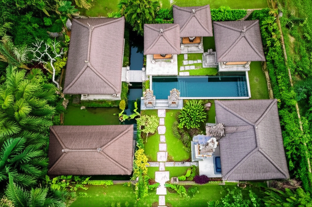 Aerial view of a traditional Balinese villa showcasing harmonious integration of architecture and nature, reflecting Tri Hita Karana principles.