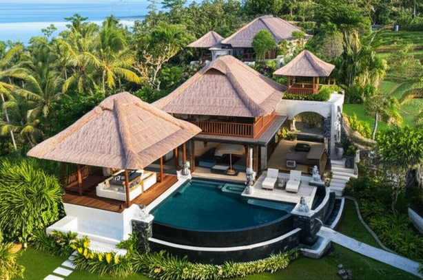 Aerial view of a luxurious Balinese villa, showcasing the principles of Tri Hita Karana with open-plan layouts, thatched roofing, and integration with the natural environment.