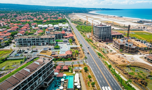Aerial view of Bali showcasing diverse construction projects, including luxury resorts, villas, and infrastructure improvements, highlighting the island's economic boom driven by tourism and investment.