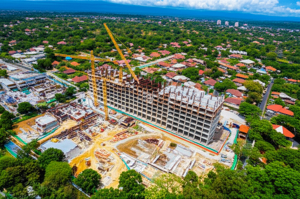 Aerial view of Bali showing construction sites, infrastructure development, and lush tropical landscape.