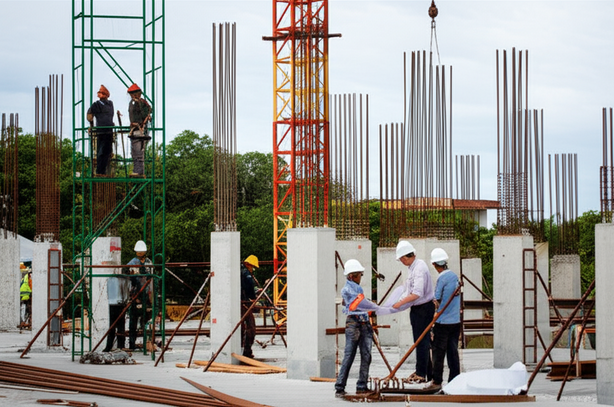 Illustration of a general contractor overseeing a commercial construction project in Bali, with workers, cranes, and tropical scenery.
