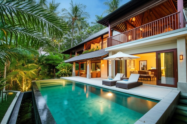 A luxurious Bali villa with a swimming pool, lush landscaping, and modern architecture, showcasing the beauty of a tropical paradise.