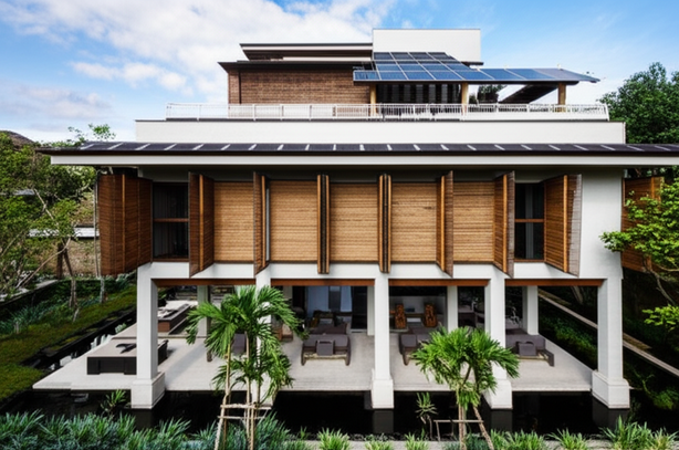 A modern, sustainable commercial building in Bali, integrating traditional Balinese architectural elements with eco-friendly materials like bamboo and solar panels, designed for energy efficiency and harmony with nature.